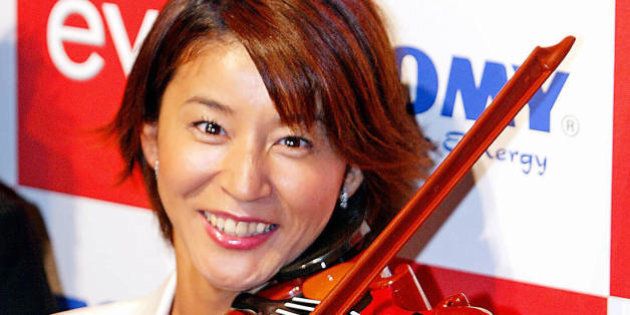 Japanese famous violinist Chisako Takashima tries to play a virtual toy violin 'Evio', produced by Japanese toy giant Tomy for a sales promotion in Tokyo 28 July 2003 as it will start to sell from 31 July with a price of 7,000 yen (59 USD). The Evio, which has an optical sensor on its string and enables to read the motion of the bow, plays digital music contents stored in the media cartridges. AFP PHOTO / Yoshikazu TSUNO (Photo credit should read YOSHIKAZU TSUNO/AFP/Getty Images)