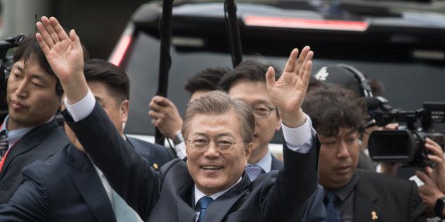 South Korea's President Moon Jae-In waves to his supporters as he greets members of staff as he arrives near the presidential Blue House in Seoul on May 10, 2017.Left-leaning former human rights lawyer Moon Jae-In began his five-year term as president of South Korea following a landslide election win after a corruption scandal felled the country's last leader. / AFP PHOTO / Ed JONES (Photo credit should read ED JONES/AFP/Getty Images)