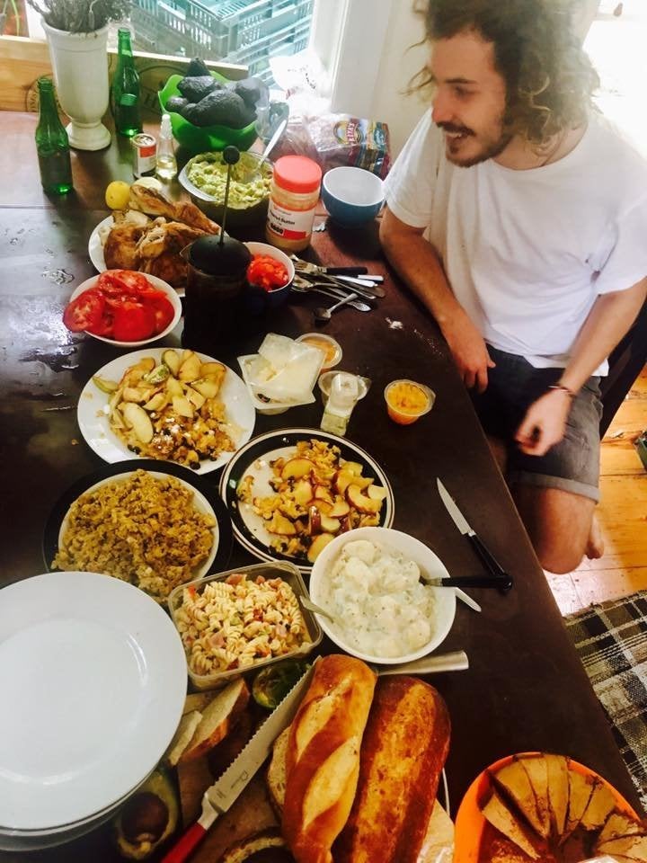 Cameron Macleish devant un repas pantagruélique à base d'aliments sortis des poubelles dans sa communauté de résidence lors de l'un de ses voyages.