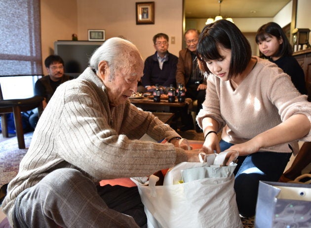 配布するための文章を紙袋から取り出す伊東さん