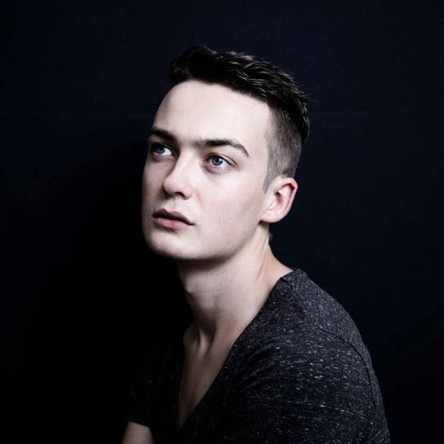 portrait of a young man against a black background