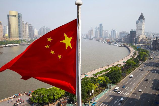 Chinese flag overlooking cityscape, Shanghai, China (Photo: Rolf Bruderer/Getty Images)