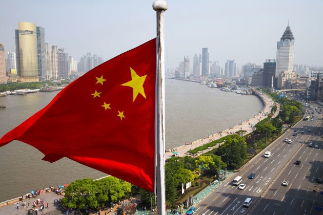 Chinese flag overlooking cityscape, Shanghai, China (Photo: Rolf Bruderer/Getty Images)