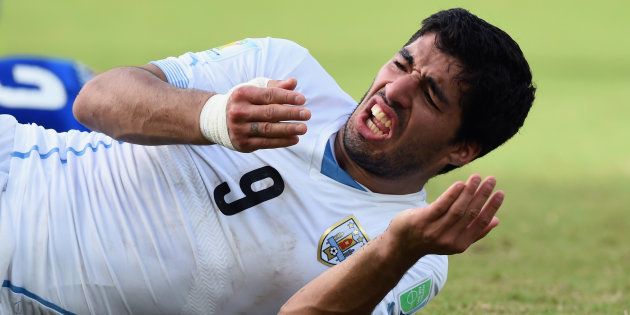 ワールドカップ・ブラジル大会で、試合中にイタリア選手に噛み付いたにもかかわらず、自身が痛がる仕草を見せるウルグアイのスアレス＝2014年6月24日、ブラジル・ナタール