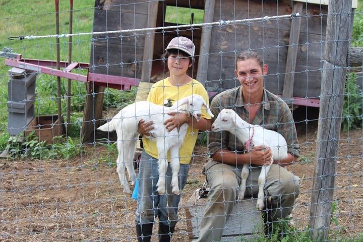 農場のスタッフと子ヤギを抱く鷹之介君（左）＝アメリカ・マサチューセッツ州のライトロック農場