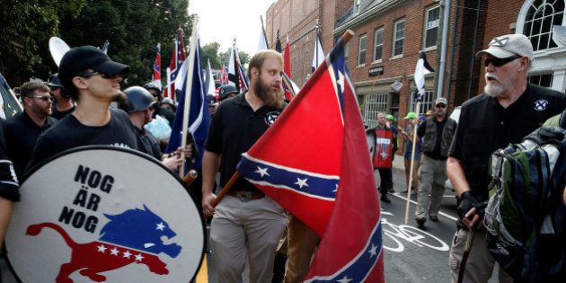White supremacists carry a shield and Confederate flag as they arrive at a rally in Charlottesville, Virginia, U.S., August 12, 2017. REUTERS/Joshua Roberts