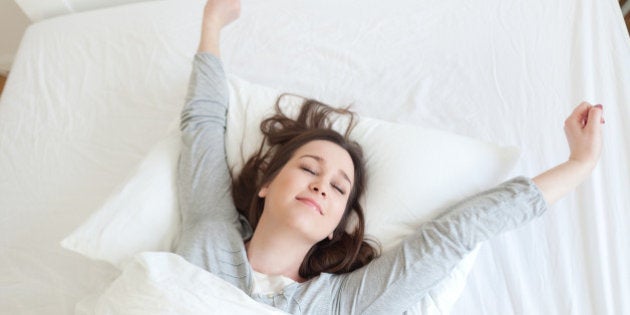 Young beautiful, woman waking up fully rested.