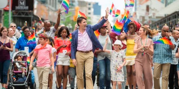 Prime Minister Justin Trudeau waves to the crowd as he, his wife Sophie Gregoire Trudeau and their children Xavier and Ella-Grace march in the Pride Parade in Toronto, June 25, 2017. / AFP PHOTO / GEOFF ROBINS (Photo credit should read GEOFF ROBINS/AFP/Getty Images)