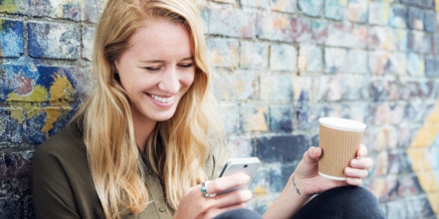 Young woman with smart phone and coffee.