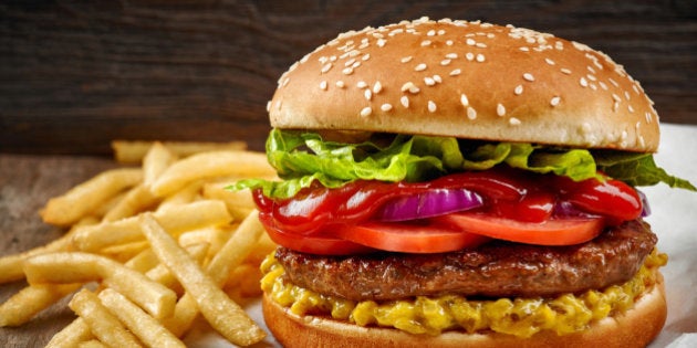 fresh tasty burger and french fries on wooden table