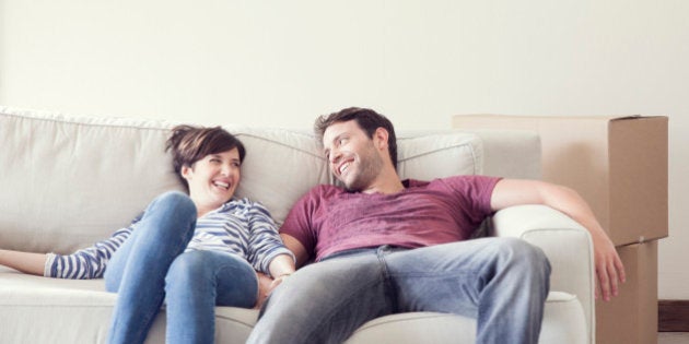 Couple relaxing on sofa while moving house