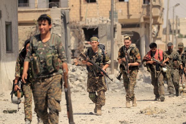 市街地を進むシリア民主軍の兵士ら＝ラッカ、8月9日