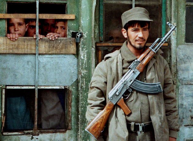 カラシニコフ銃を持って刑務所の監視にあたる青年＝1996年、アフガニスタン