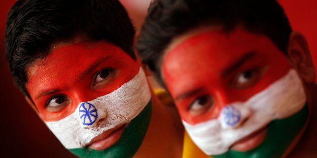 インドの国旗を顔にペイントし、独立記念日を祝うインド人の子ども。インドでは、子どもたちに高学歴を望む家庭が急速に増えている＝2014年8月、インド北部のジャンムー