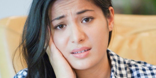 Woman sorting through bills on sofa