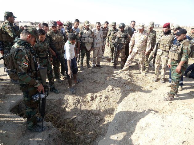 ISに処刑されたとみられる人たちの遺体が見つかった場所を調べるイラク軍兵士ら＝11月11日、イラク北部ハウィジャ
