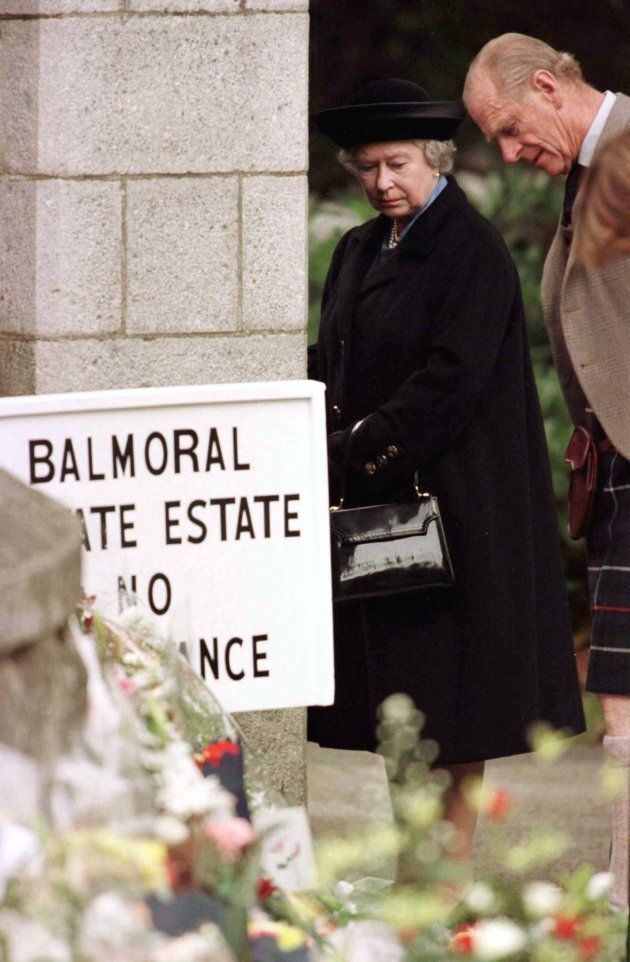 スコットランド・バルモラル城の門前で、故ダイアナ元英皇太子妃にささげられた花束や弔辞に見入るエリザベス女王とフィリップ殿下（1997年9月4日）