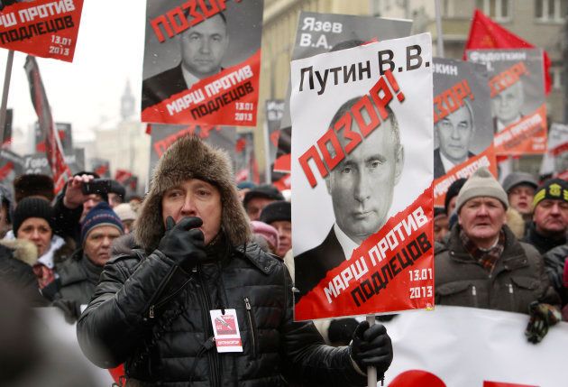 プーチン政権を批判する野党勢力の集会。プラカードにはプーチン氏や与党議員らの写真が印刷されており、「恥」と書かれている＝2013年1月、モスクワ