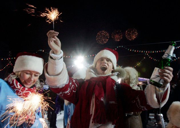 花火と酒瓶を持ちながら新年を祝うロシア人＝2008年1月1日、モスクワ・赤の広場
