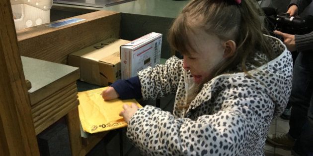 CORRECTS YEAR TO 2015, NOT 2013 - Safyre Terry, 8, opens a gift Wednesday, Dec. 9, 2015, at a post office near her home in Rotterdam, N.Y. Safyre, who lost her father and three younger siblings and was burned over 75 percent of her body in a May 2013 house fire, has been receiving cards and gifts from across the country since her custodial aunt posted a photo of her on Facebook with a message saying sheâd like to get cards for a Christmas tree display stand. The post has been shared tens of thousands of times, and a crowd funding site has generated more than $177,000 for the family. (AP Photo/Mary Esch)