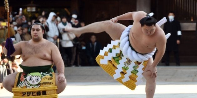 Mongolian-born sumo grand champion, or 'yokozuna', Hakuho (R) performs a ring-entering ceremony beside Tsuyuharai Kaisei (L) at Meiji Shrine in Tokyo on January 7, 2015. Three sumo grand champions Hakuho, Kakuryu and Harumafuji, as well as Sumo Association leaders, made their New Year pilgrimage to the shrine on January 7, pledging to work hard to make Japan's national sport a success this year. AFP PHOTO / TOSHIFUMI KITAMURA (Photo credit should read TOSHIFUMI KITAMURA/AFP/Getty Images)