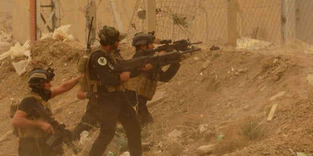 Security forces defend their headquarters against attacks by Islamic State extremists during sand storm in the eastern part of Ramadi, the capital of Anbar province, 115 kilometers (70 miles) west of Baghdad, Iraq, Thursday, May 14, 2015. Islamic State extremists tend to take advantage of bad weather when they attack Iraqi security forces positions, an Iraqi officer said. (AP Photo)