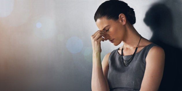 Studio shot of a businesswoman looking stressed out against a grey background