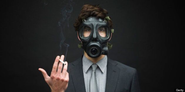 Businessman Wearing Gas Mask and Smoking Cigarette