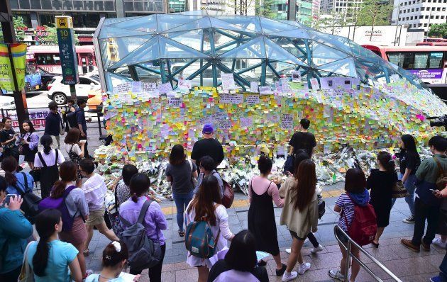 South Koreans leave messages written on post-it notes at an exit of Gangnam subway station, which has been turned into a mini shrine for a 23-year-old woman who was stabbed to death by a stranger the previous night in a nearby public bathroom, in Seoul on May 20, 2016. The brutal murder of a woman in Seoul's upmarket Gangnam district has triggered a public outcry and a debate over what some see as a growing streak of violent misogyny in South Korea. / AFP / JUNG YEON-JE (Photo credit should read JUNG YEON-JE/AFP/Getty Images)
