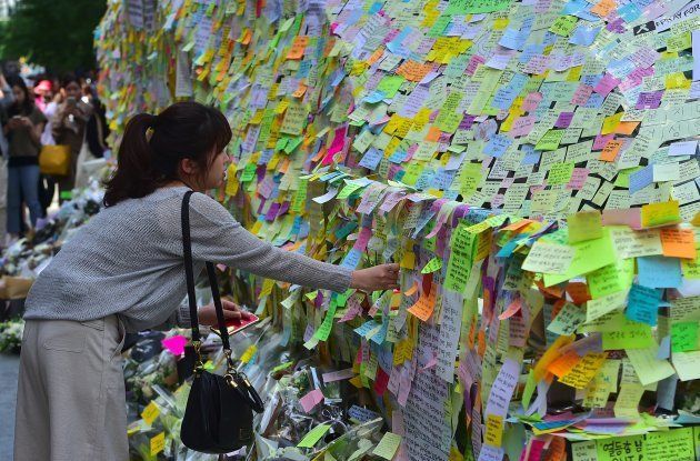 South Koreans leave messages written on post-it notes at an exit of Gangnam subway station, which has been turned into a mini shrine for a 23-year-old woman who was stabbed to death by a stranger the previous night in a nearby public bathroom, in Seoul on May 20, 2016. The brutal murder of a woman in Seoul's upmarket Gangnam district has triggered a public outcry and a debate over what some see as a growing streak of violent misogyny in South Korea. / AFP / JUNG YEON-JE (Photo credit should read JUNG YEON-JE/AFP/Getty Images)