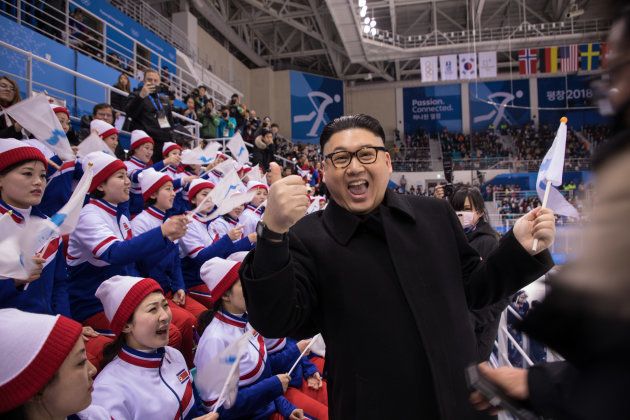 A man impersonating North Korean leader Kim Jong Un gestures as he stands before North Korean cheerleaders attending the Unified Korean ice hockey game against Japan during the Pyeongchang 2018 Winter Olympic Games at the Kwandong Hockey Centre in Gangneung on February 14, 2018. / AFP PHOTO / YELIM LEE (Photo credit should read YELIM LEE/AFP/Getty Images)