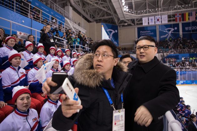 A man impersonating North Korean leader Kim Jong Un is removed by security offices after waving a unified Korean flag before North Korean cheerleaders attending the Unified Korean ice hockey game against Japan during the Pyeongchang 2018 Winter Olympic Games at the Kwandong Hockey Centre in Gangneung on February 14, 2018. / AFP PHOTO / YELIM LEE (Photo credit should read YELIM LEE/AFP/Getty Images)