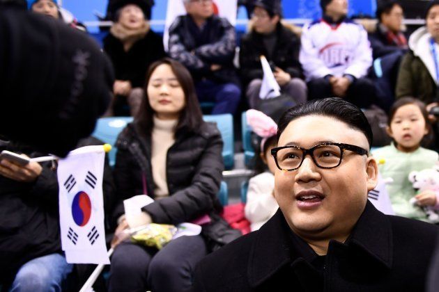 A Kim Jong Un impersonator sits with spectators during the final period of the women's preliminary round ice hockey match between Unified Korea and Japan during the Pyeongchang 2018 Winter Olympic Games at the Kwandong Hockey Centre in Gangneung, South Korea on February 14, 2018. / AFP PHOTO / Brendan Smialowski (Photo credit should read BRENDAN SMIALOWSKI/AFP/Getty Images)