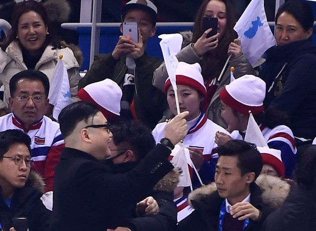 A Kim Jong Un impersonator cheers in front of North Korean cheerleaders during the final period of the women's preliminary round ice hockey match between Unified Korea and Japan during the Pyeongchang 2018 Winter Olympic Games at the Kwandong Hockey Centre in Gangneung, South Korea on February 14, 2018. / AFP PHOTO / Brendan SMIALOWSKI (Photo credit should read BRENDAN SMIALOWSKI/AFP/Getty Images)