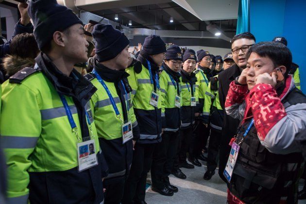 South Korean police surround a man impersonating North Korean leader Kim Jong Un after he appeared before North Korean cheerleaders attending the Unified Korean ice hockey game against Japan during the Pyeongchang 2018 Winter Olympic Games at the Kwandong Hockey Centre in Gangneung on February 14, 2018. / AFP PHOTO / YELIM LEE (Photo credit should read YELIM LEE/AFP/Getty Images)