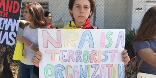 「NRAはテロリストの組織だ」というプラカードをかかげる抗議デモ参加者