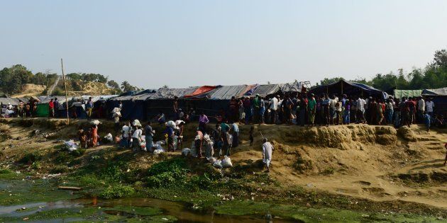 Rohingya refugees collect relief material next to a settlement near the 'no man's land' area between Myanmar and Bangladesh in Tombru in Bangladesh's Bandarban on February 27, 2018.Hundreds of desperate Rohingya Muslims still pour over the Myanmar border into Bangladesh camps every week, six months into the refugee crisis. / AFP PHOTO / MUNIR UZ ZAMAN (Photo credit should read MUNIR UZ ZAMAN/AFP/Getty Images)