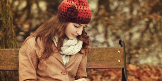 girl reading a book in the autumn forest