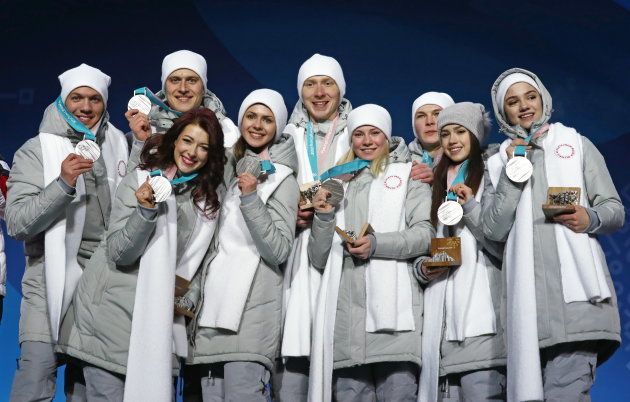 フィギュアスケート団体戦で銀メダルに輝いたロシア人らのチーム。いずれも白いマフラーが上着の同じ位置にぴったりくっついている＝2月12日