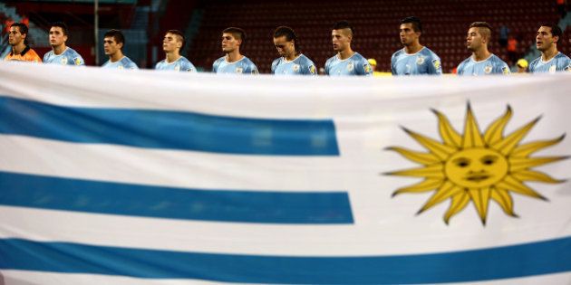 Players of Uruguay listen to their national anthem as they stand next to their national flag prior to their Semi-Final football match against Iraq at the FIFA Under 20 World Cup at Huseyin Avni Aker stadium in Trabzon on July 10, 2013. AFP PHOTO/BEHROUZ MEHRI +++ RESTRICTED TO EDITORIAL USE +++ (Photo credit should read BEHROUZ MEHRI/AFP/Getty Images)
