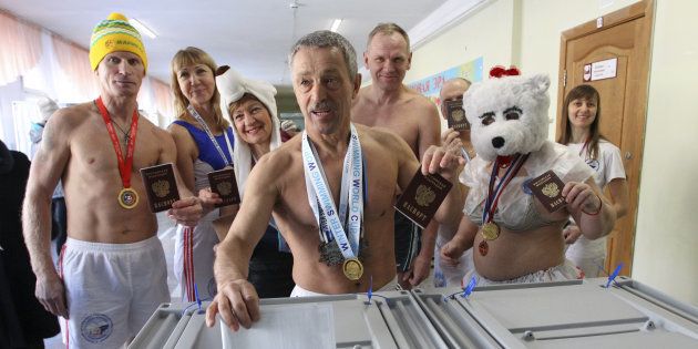コスプレ姿や上半身裸のまま投票する寒中水泳クラブのメンバー。メンバーらは投票所の前で組体操のパフォーマンスも披露した＝3月18日、ロシア中部のバルナウル