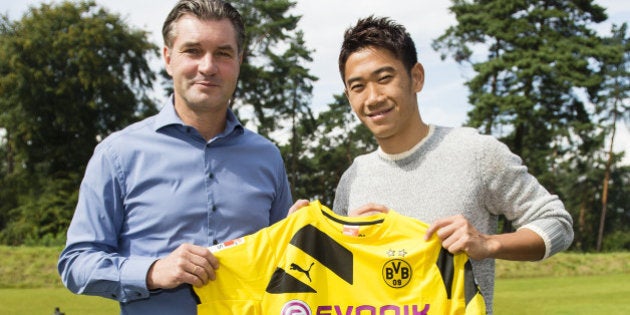 DORTMUND, GERMANY - AUGUST 31: (EXCLUSIVE COVERAGE) New signing Shinji Kagawa (L) of Dortmund poses with Michael Zorc, Borussia Dortmund's Director Sports Sportdirektor on August 31, 2014 in Dortmund, Germany. (Photo by Alexandre Simoes/Borussia Dortmund/Getty Images)