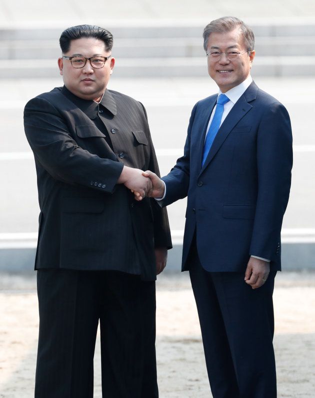軍事境界線を歩いて越え、韓国側で文在寅大統領（右）と握手する北朝鮮の金正恩・朝鮮労働党委員長＝4月27日、板門店