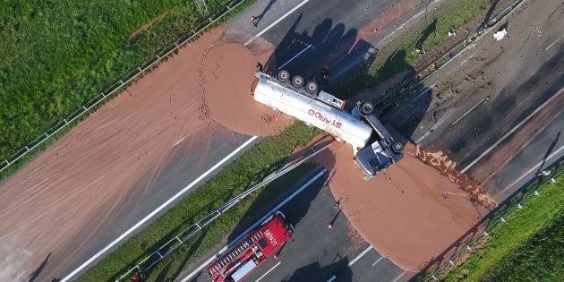 ポーランド西部で9日、横転して中央分離帯を突き破ったトラック。運んでいたチョコレートが高速道路上に流れ出した。ポーランドのテレビ局ＴＶＮの映像から (Photo credit should read STR/AFP/Getty Images)