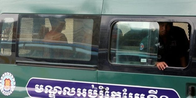 Uon Chhin and Yeang Sothearin, former journalists of the Radio Free Asia (RFA), sit inside a police vehicle as they arrive for a bail hearing at the Appeal Court in Phnom Penh, Cambodia on April 19, 2018. © 2018 Reuters / Samrang Pring