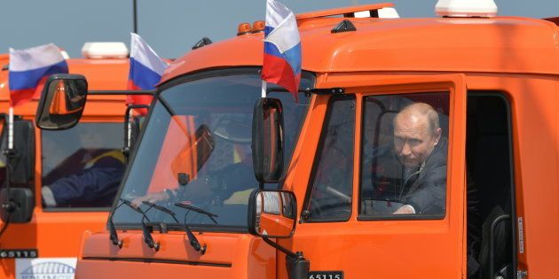 クリミア橋を渡るため、トラックに乗り込むロシアのプーチン大統領＝5月15日