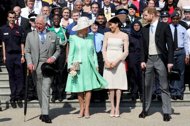 手前左から、チャールズ皇太子、カミラ夫人、メーガン妃、ヘンリー王子＝21日、ロンドン、バッキンガム宮殿
