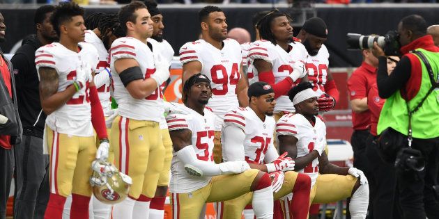 国歌斉唱中に片膝をついて起立を拒否するサンフランシスコ・49ersの選手ら＝2017年10月、テキサス州ヒューストン