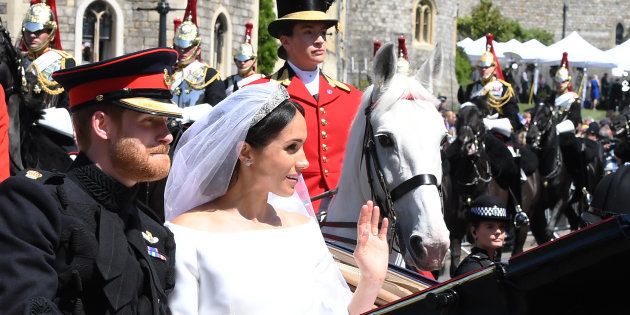 結婚のお祝いに集まった人々へ手を振るメーガン妃とヘンリー王子＝2018年5月19日