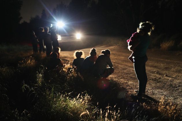 国境パトロールによって拘束された、女性と子供のグループ。彼らはリオ・グランデ川をボートで渡って、アメリカに来た。移民手続きセンターに連れていかれた後、親子は別の場所で拘束される可能性がある。2018年6月12日テキサス州マッカレンで撮影。
